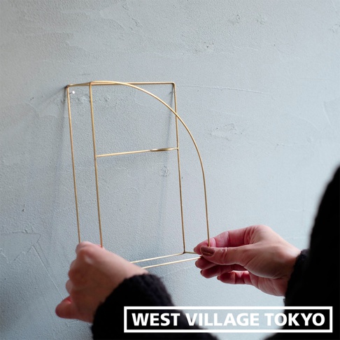 黃銅線條書架款掛擺兩用花器，整體呈現半圓拱形，由細緻的黃銅金屬線條構成，簡約的結構適合掛在牆面上展示植栽或擺飾。