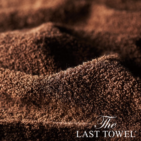 The LAST TOWEL 魔法瞬吸純棉柔長毛巾，特寫展示其柔軟蓬鬆的長毛圈織法，呈現深棕色調，質感細膩，展現純棉材質的吸水力與舒適觸感。