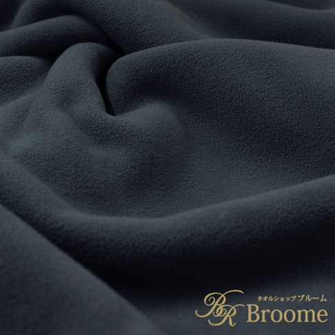 深灰色絨毛材質的保暖毯，表面有細膩的絨毛紋理，呈現柔軟蓬鬆的質感，布料有自然的褶皺。