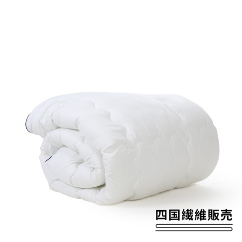 純白色雙人羽絨被，一角藍色滾邊，被子捲起，上方印有日文文字。