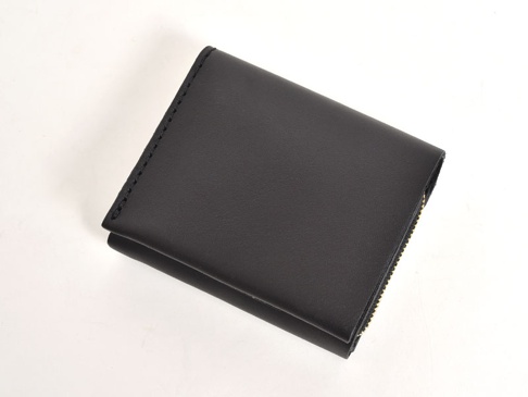 黑色皮革直式雙折短夾，邊緣縫線清晰，右側有金色拉鍊。