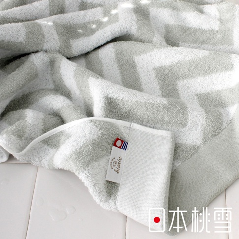 今治北歐方巾，採用淺灰色幾何圖紋，材質柔軟，觸感舒適。方巾邊緣有品牌標籤，顯示「hiorie」及「MADE IN JAPAN」字樣。