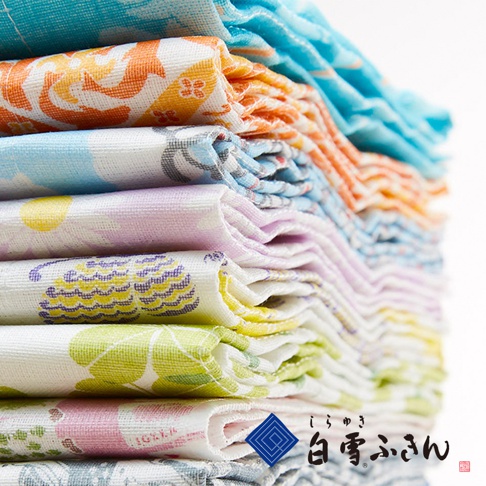 一疊友禪染長拭巾，色彩豐富，包含藍色、橘色、粉色、紫色、黃色、綠色等，布料上有傳統日式圖案，材質看起來是吸水性佳的棉質。