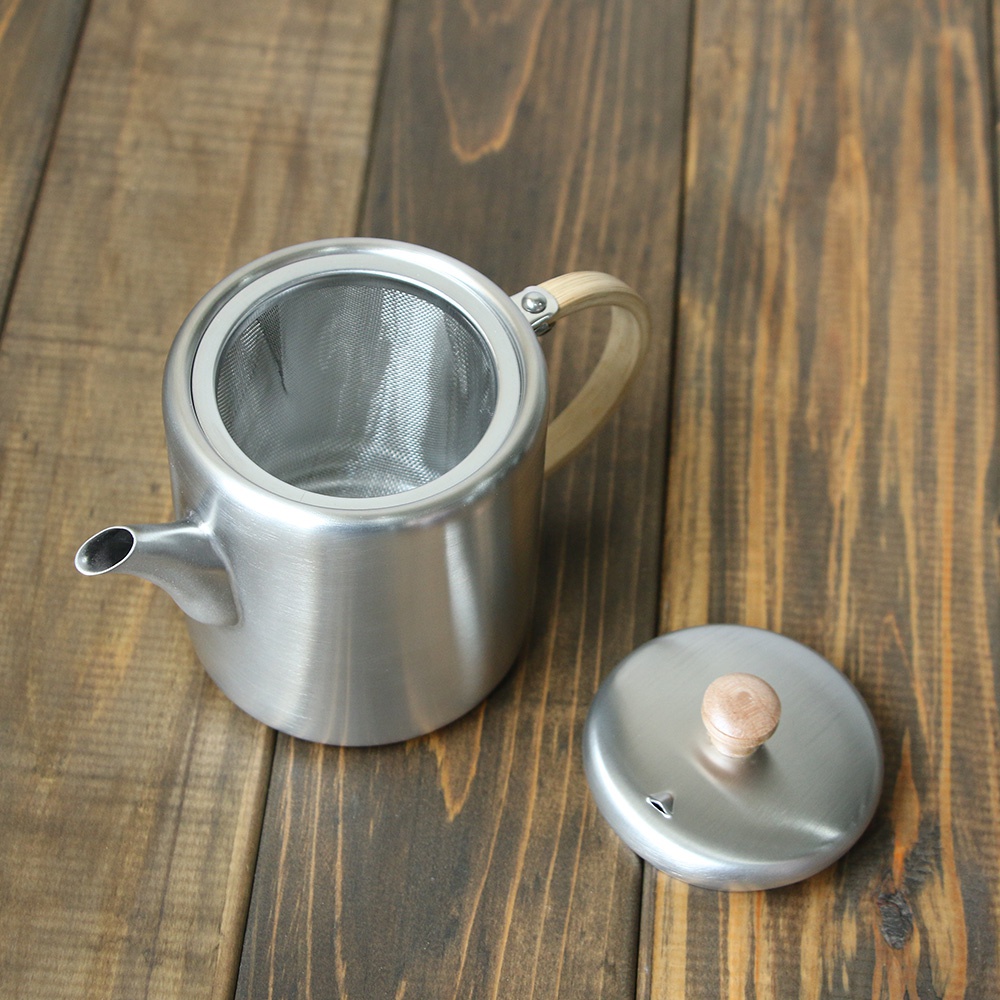 霧面不鏽鋼直筒茶壺，附側邊木質把手及濾網，另一側為同材質的壺蓋，帶有木質圓形提鈕。