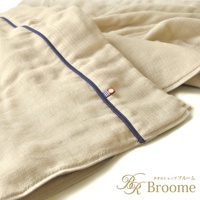 米色五層紗四季被，表面有細緻紋理，邊緣滾有深藍色滾邊，並有一個帶有紅、藍、白色條紋的小標籤。