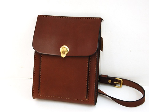 職人手作皮革厚實單肩包 (CP-61)，採用深棕色皮革製成，包身方正，正面配有金色旋轉鎖扣，附有可調節的皮質單肩帶，帶扣亦為金色。