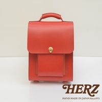 職人手作皮革復古後背包，紅色皮革，設有頂部提把、正面翻蓋開合及金屬鎖扣，前方有一個方形口袋，底部有四個金屬腳釘。