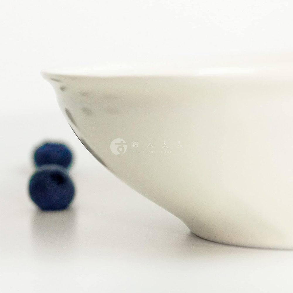 Ciel 美濃燒簡約素雅釉彩淺碗，陶瓷材質，碗身呈米白色，邊緣有細緻的黑色釉彩點綴，背景虛化，有兩顆藍色漿果。