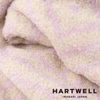 今治柔彈伸縮美肌枕套，以柔軟的純棉材質製成，呈現米白與淡粉色條紋交織的紋理，觸感蓬鬆。