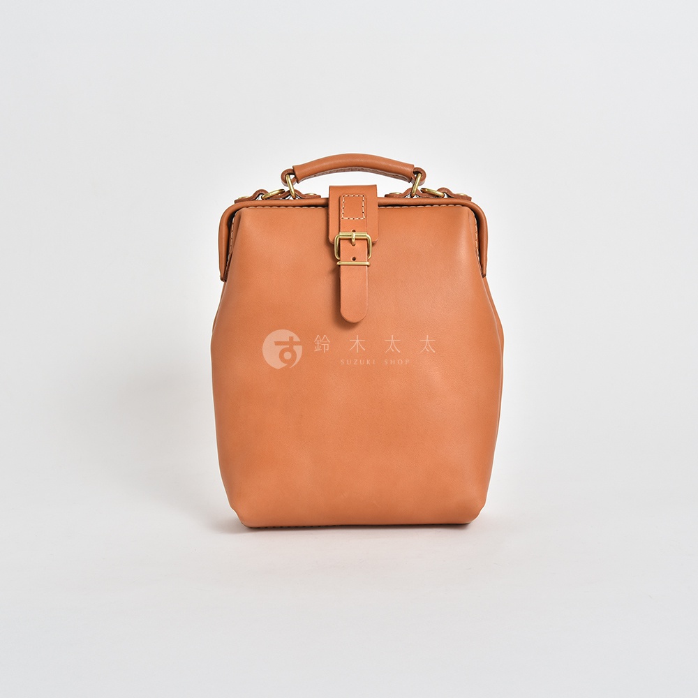 職人手作皮革迷你軟皮杜勒斯包，採用棕褐色皮革製成，具備手提把、金屬扣環及皮製繫帶，風格經典復古。