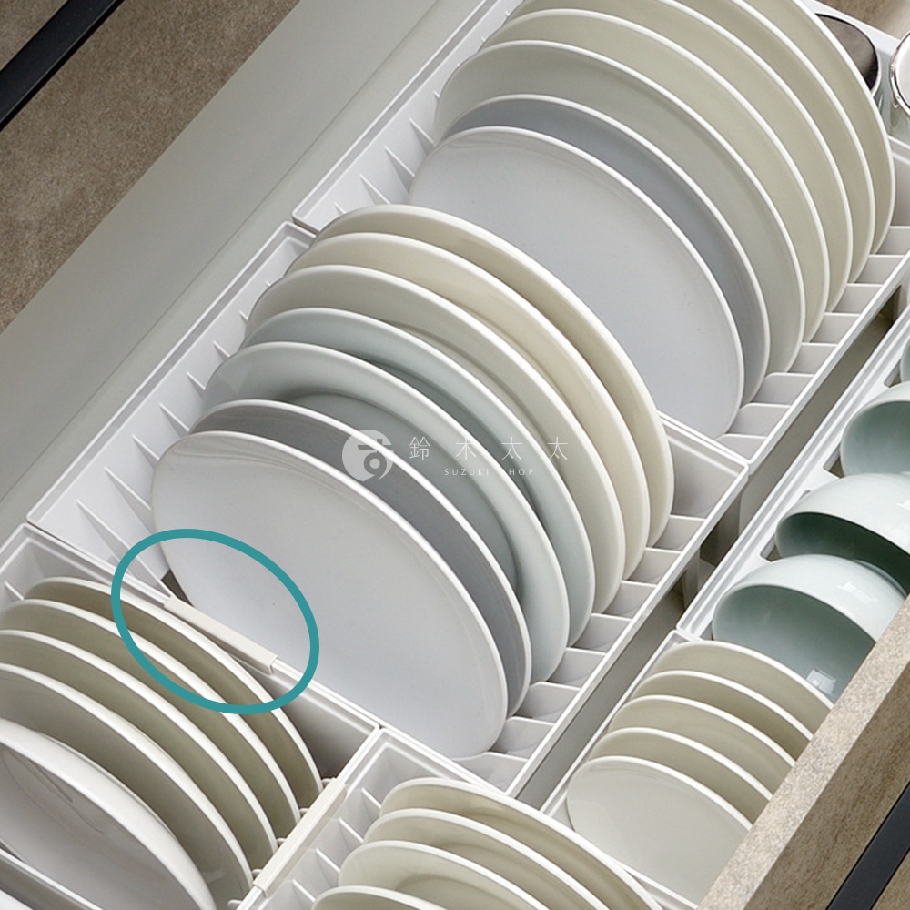 白色抽屜式餐盤收納架，內部整齊擺放著多層次的白色、米白色及灰色盤子，部分盤子邊緣有藍色圓圈標示。