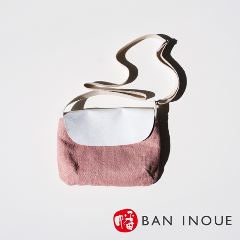 BAN INOUE 蚊帳棉裂織手提袋，粉紅色裂織布料搭配白色皮革翻蓋，斜背帶自然垂落，陰影投射於白背景上。
