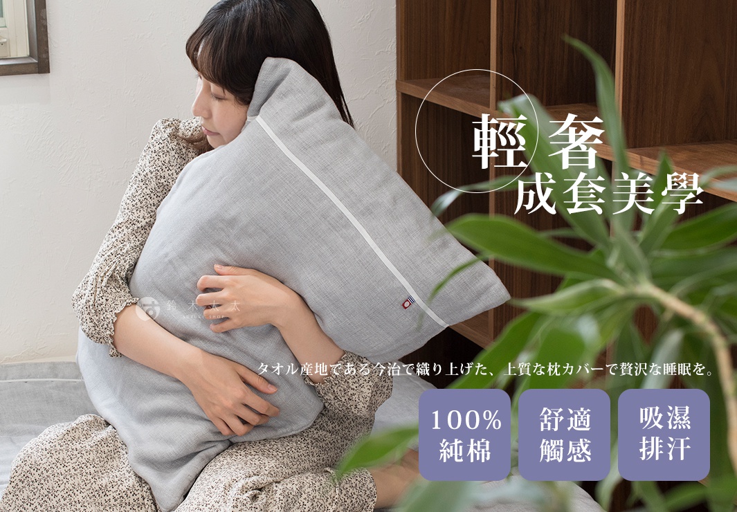 一位女士抱著一個淺灰色五層紗枕套，枕套上有白色線條裝飾。