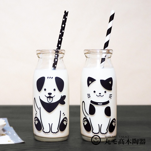 一組兩個的玻璃牛奶瓶，分別印有可愛的黑白狗和貓圖案。瓶內裝有牛奶，並各插著一根黑白條紋或圓點吸管。