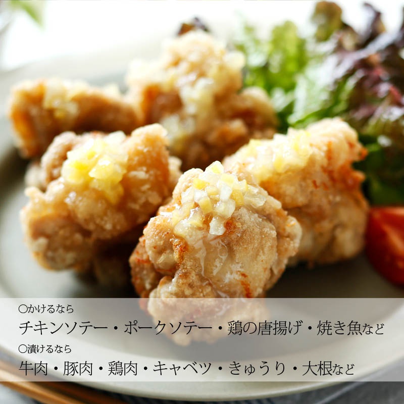 盤中盛有幾塊炸雞塊，表面淋上由黃色和白色小塊組成的醬料，背景有綠色生菜和紅色番茄塊。