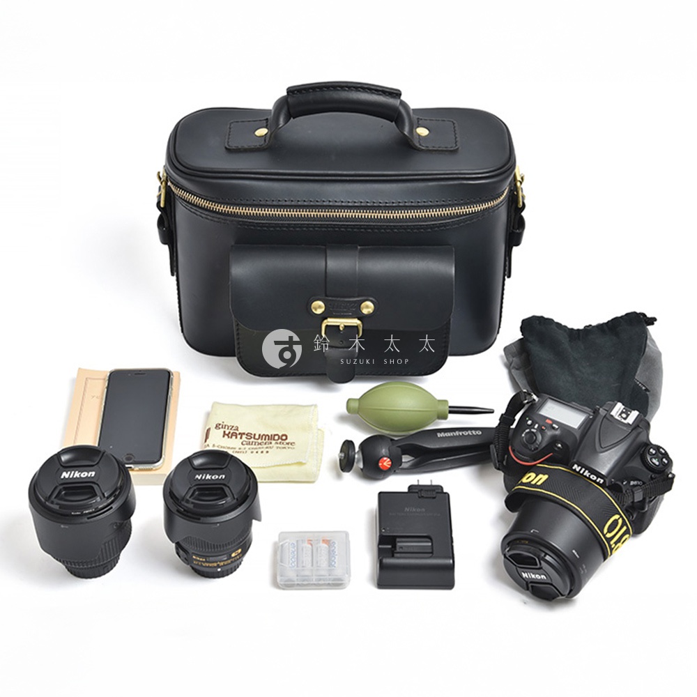 黑色的HERZ皮革相機包，附有前袋、手柄和多種攝影配件，包括鏡頭、電池、充電器、手機、鏡頭清潔組、氣吹和三腳架。