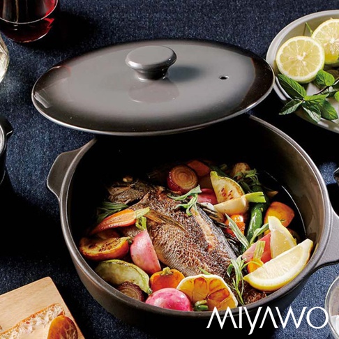 IH系列7號導熱加強型陶土湯鍋，漸層可可黑，鍋內盛有烤魚與豐富蔬菜，鍋蓋半開，旁有檸檬與薄荷葉裝飾。