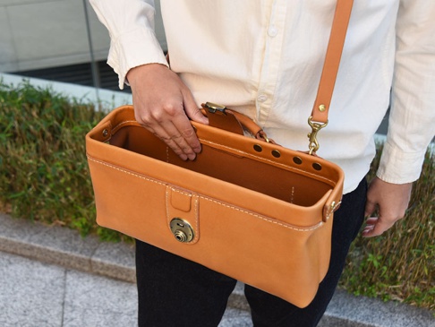 職人手作皮革橫長形杜勒斯單肩包 (CW-4)，採用天然皮革製成，經典棕色，設計簡潔，配有金屬旋鎖和可調節肩帶。