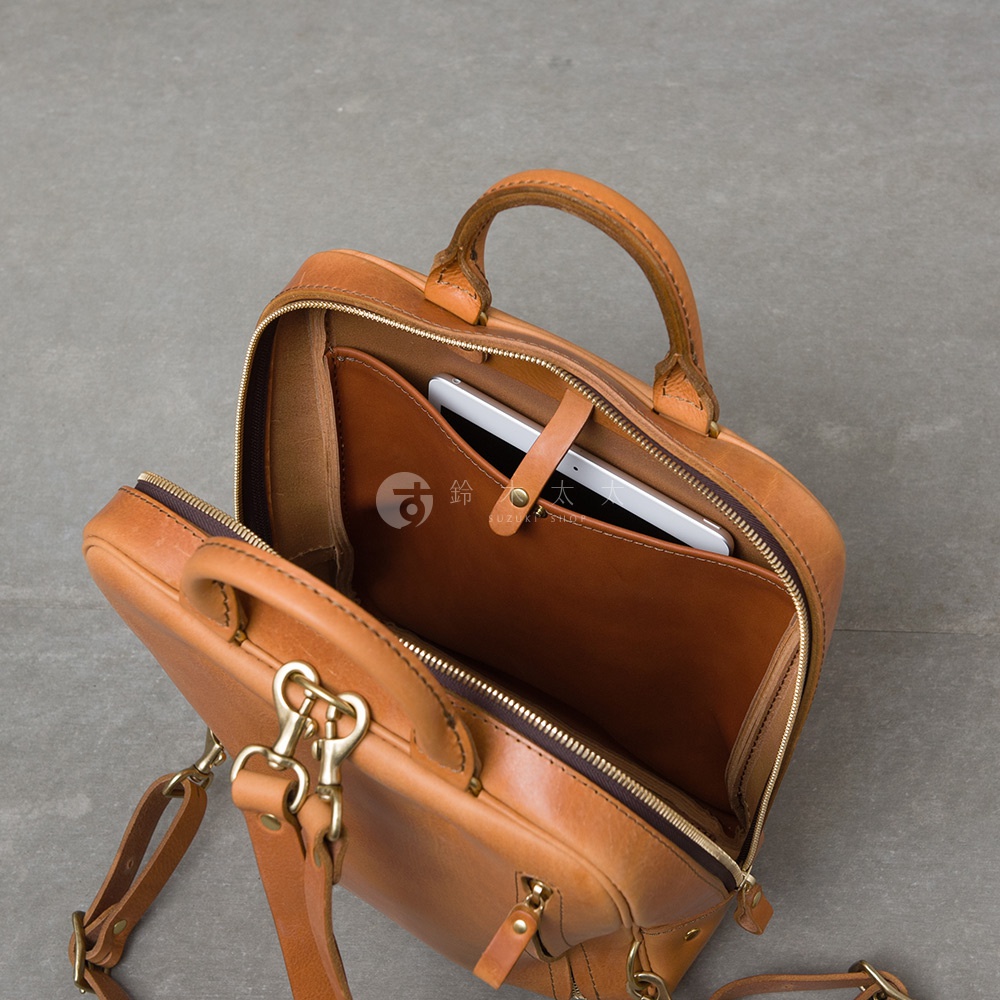 職人手作皮革Organ商務後背包，展示內部結構，一個平板電腦置於內袋中
