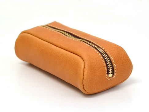 棕色皮革製成的圓角收納筆袋，配有黃銅色拉鍊和米色縫線。