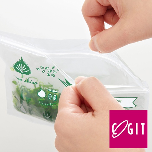 透明塑膠保鮮袋，印有綠色植物圖案及可愛卡通臉，內裝蔥花等綠色辛香料。雙手正打開袋口。