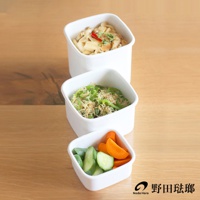 三個白色琺瑯方型保存容器，分別裝有不同食物：最上方裝有香菇與紅辣椒，中間裝有青椒與小魚乾，最下方裝有小黃瓜片與紅蘿蔔塊。