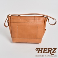 職人手作皮革復古郵差包，採用天然棕色皮革製作，包身有縫線細節，前有貼袋設計，搭配可調節的肩帶，整體風格簡約大方。