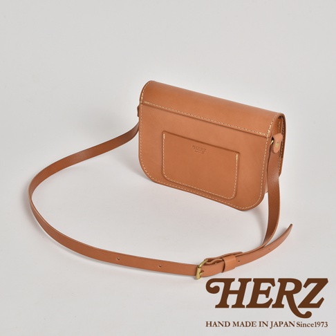 職人手作皮革翻蓋橫式單肩包，採用天然皮革材質，經典棕色調，包身帶有外袋設計，搭配可調節長度的皮革背帶，整體簡約而有質感。
