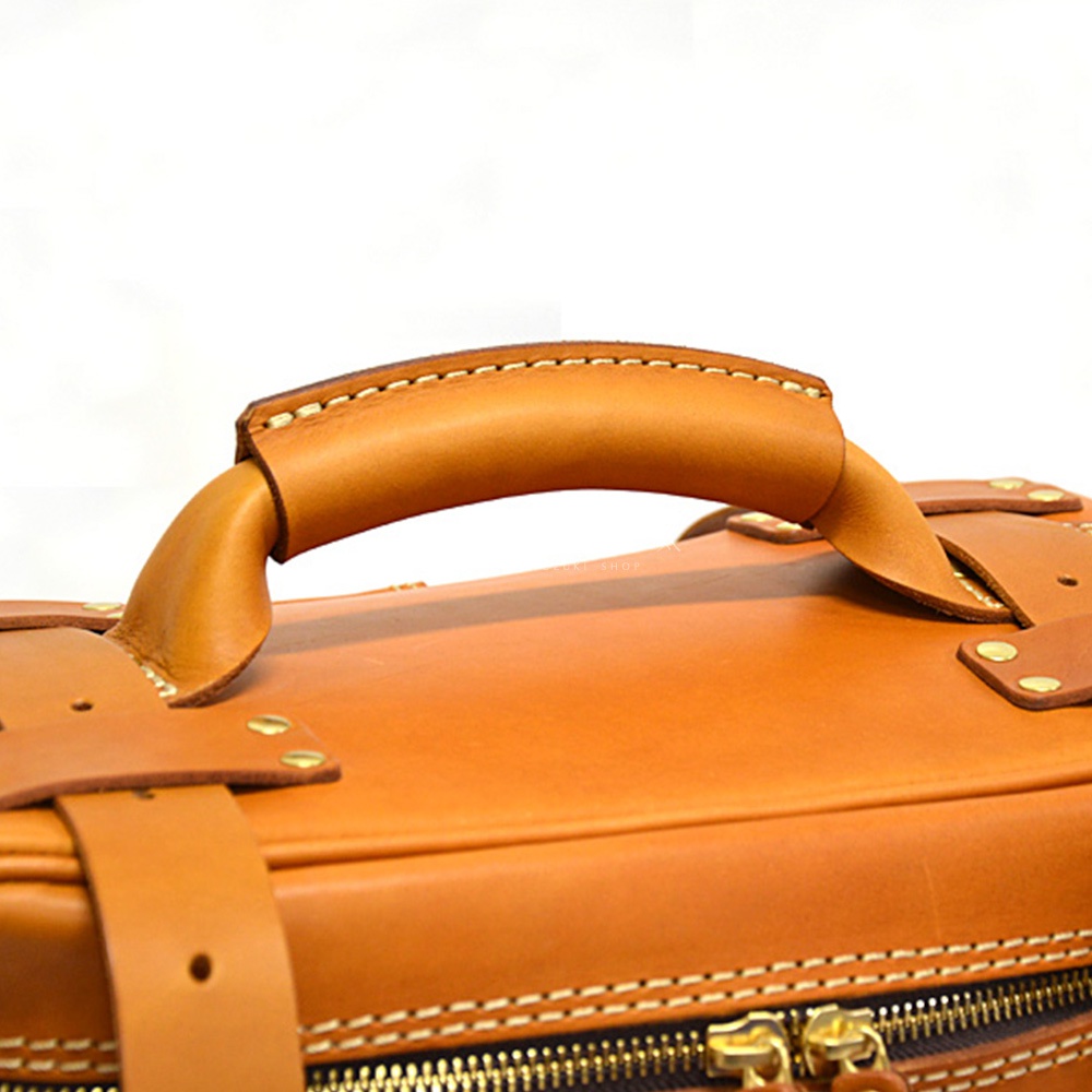 職人手作皮革大型三用旅行後背包 A-21，特寫展示棕褐色皮革提把、縫線細節及黃銅色拉鍊。