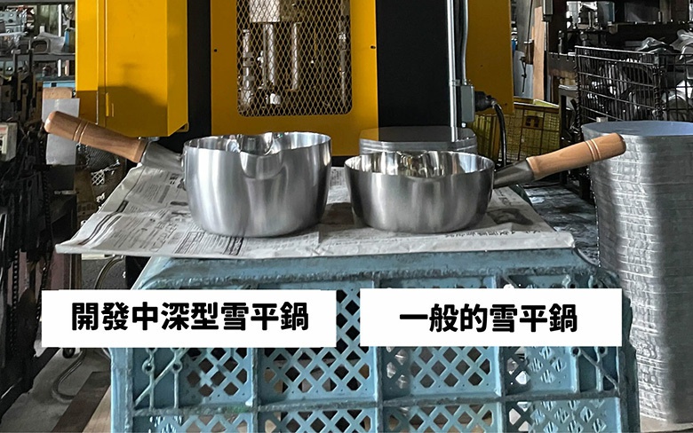 兩個不鏽鋼料理盆，一個較深，兩個都有木柄，盆緣有波浪形狀。