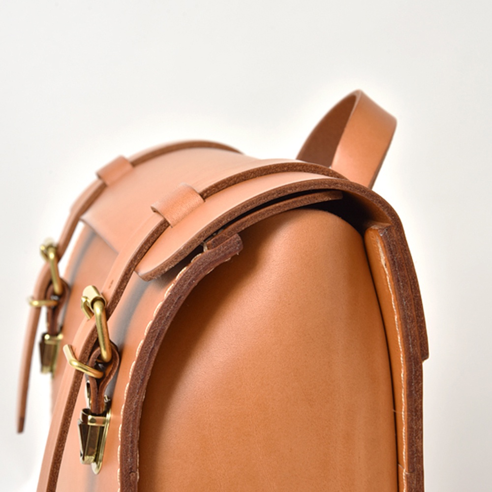 職人手作皮革後背包 R-31 (厚實版)，採用淺棕色皮革，配有黃銅色金屬扣環和針扣，展現精緻工藝。