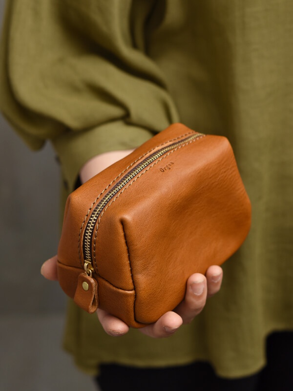 職人手作皮革Organ拉鍊收納包，S尺寸，呈方形，皮革材質，顏色為溫暖的焦糖棕色，配有黃銅色拉鍊和皮革拉頭，整體設計簡潔實用。
