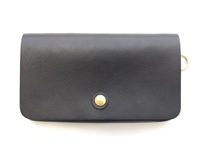 黑色皮革長夾，正面中央有金色按扣，右側邊緣有一個金色 D 型環。