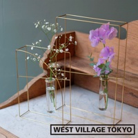 黃銅材質的書架造型掛擺兩用花器，包含兩個尺寸不同的幾何框架，每個框架內置一個玻璃試管，分別插有白色滿天星和紫色香豌豆花。