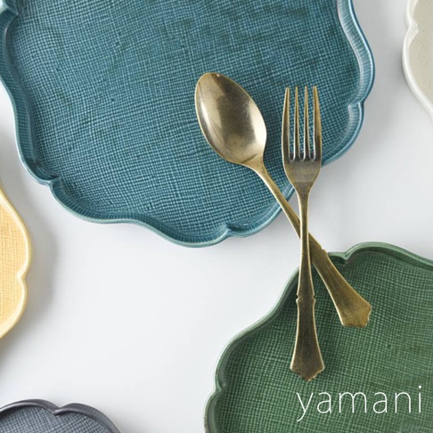 青藍色、綠色、黃色及灰色美濃燒花型主食盤，表面帶有細膩紋理，盤中擺放金色湯匙與叉子。