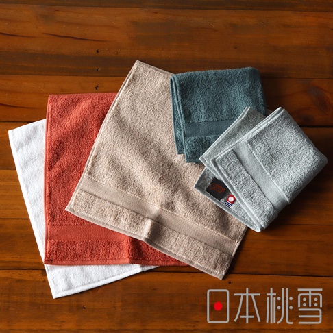 今治匹馬棉方巾，展示白色、橘紅色、米色、藍綠色及兩種淺灰色，質地柔軟，紋理清晰，帶有品牌標籤。