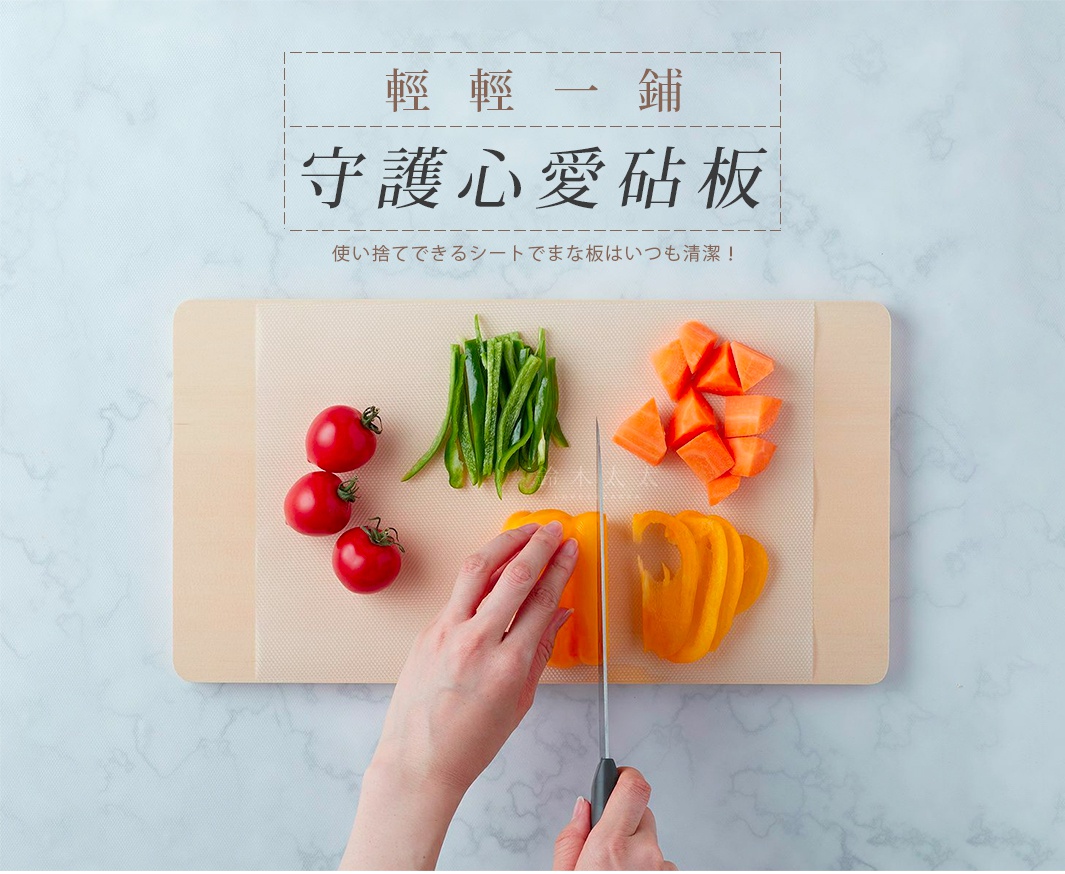 淺色紋理的捲筒式砧板保潔墊片，上面擺放著番茄、切塊的青椒、胡蘿蔔丁和切片的黃甜椒，有人手持菜刀切著黃甜椒。