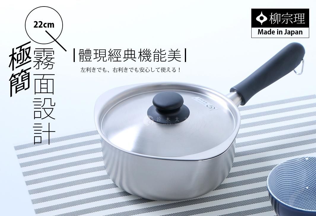 一張柳宗理品牌的不鏽鋼霧面單手鍋商品宣傳圖，鍋具直徑為22公分並附有鍋蓋，設計呈現極簡霧面質感。鍋身兩側有特殊的傾倒口設計，適合左右手使用者操作，鍋具放置在條紋餐墊上，整體氛圍簡約實用，展現日式經典機能美。