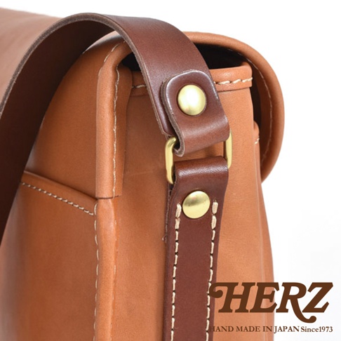 職人手作皮革傳統釣魚包，採用棕色皮革製成，附有皮革肩帶和金屬扣環。包包側面有縫線細節，整體呈現復古風格。