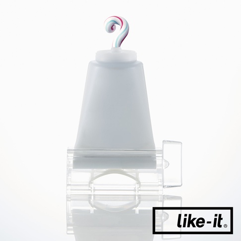 半透明白色塑料製的手動轉轉擠牙膏夾，頂部有一個擠出的、帶有粉紅、藍色和白色條紋的牙膏。