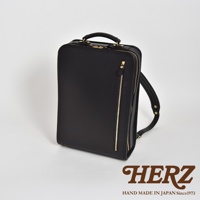 職人手作皮革商務電腦後背包 R-25，黑色。方形包體，材質為光滑皮革，配有金色拉鍊和提把，側面有雙肩帶。