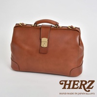 咖啡色職人手作皮革商務旅行兩用公事包，配有金色鎖扣、提把與金屬零件，整體風格復古經典，適合商務和旅行使用。