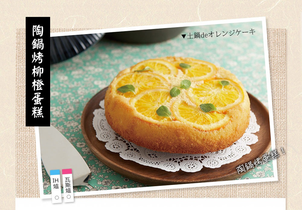 圓形橙子蛋糕，表面鋪滿橙子切片，裝飾有綠色薄荷葉，置於木質圓盤和白色蕾絲紙上。