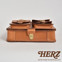 職人手作皮革三口袋三用後背包 A-19-R，採用天然皮革材質，呈現經典棕色調。包款設計有雙前袋，袋蓋均有金屬釦環，主袋開口處設有金屬鎖扣，整體風格簡約而實用。