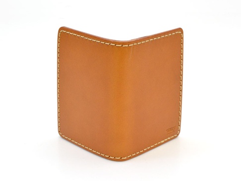 焦糖色皮革雙折票券收納夾，表面有精細的白色縫線，右下角壓印有品牌標誌。