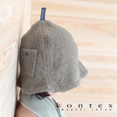 一件灰色毛巾材質的桑拿帽，帽子上有一個小口袋，並附有藍色品牌標籤。