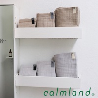 架上展示共六條毛巾，其中三條為淺褐色，三條為淺灰色。毛巾質地看起來柔軟，帶有明顯的紋理。部分毛巾上有標示尺寸的黑色標籤，分別標有「20」、「40」和「100」。