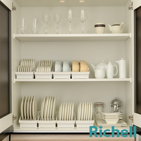櫥櫃展示架上整齊擺放著各式餐具，包含高腳杯、水杯、茶壺、各式盤子和碗，部分餐具收納在白色瀝水盤中，展現整潔有序的居家收納。