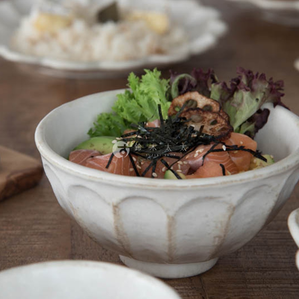 白瓷丼碗內盛裝鮭魚、酪梨、海苔絲、芝麻及鮮綠蔬菜，碗身帶有淺凹槽的六魯粉引紋路，整體風格樸實自然。