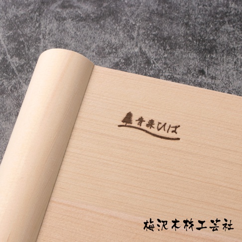 一塊淺色木紋的檜木砧板，表面有燒製的樹木與日文品牌標誌「青森ひば」和「梅沢木工芸社」，一側邊緣為圓潤造型。